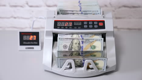 counting operations in bank. automatic mechanism counting hundred dollar banknotes. electronic counting machine in bank.