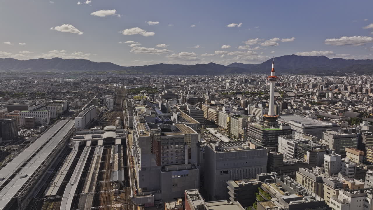 Kyoto Japan Aerial v83 flyover Higashishiokojicho capturing railway hub, landmark observation tower and Shimogyo ward cityscape against mountain landscape - Shot with Mavic 3 Pro Cine - Oct 8th 2023