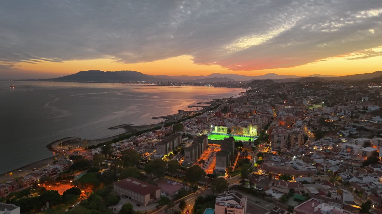 Aerial tilt down view of the city of Malaga with beautiful sunset in the background, Spain