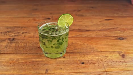 close-up of a refreshing mojito cocktail resting on a rustic wooden table in a restaurant