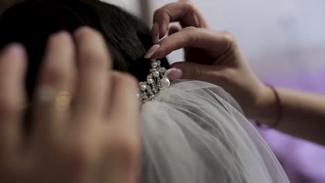 bride getting her wedding veil and tiara placed