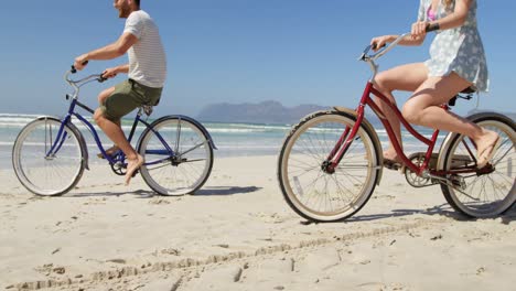 couple riding bicycle at beach on a sunny day 4k