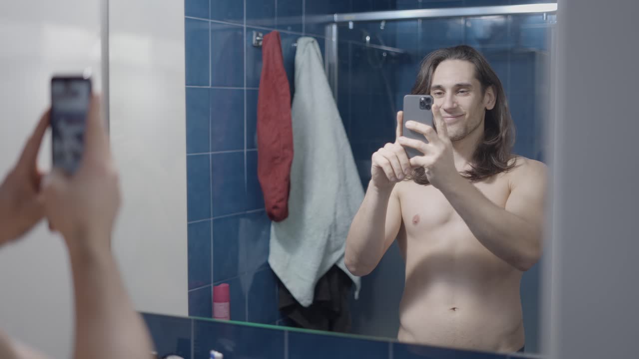 Man taking selfie in bathroom mirror