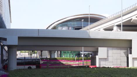 Bus-Driving-By-Al-Rashidiya-Metro-Station-In-Dubai,-UAE-On-A-Sunny-Day