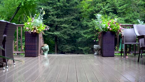 un bosque verde se encuentra detrás de una hermosa terraza, con muebles de mimbre y jardineras exuberantes