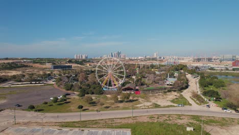 Disparo-De-Paralaje-Desde-La-Distancia-De-Una-Rueda-De-Ferris-En-Un-Pequeño-Parque-Temático-En-Un-Día-Soleado-Sin-Nubes