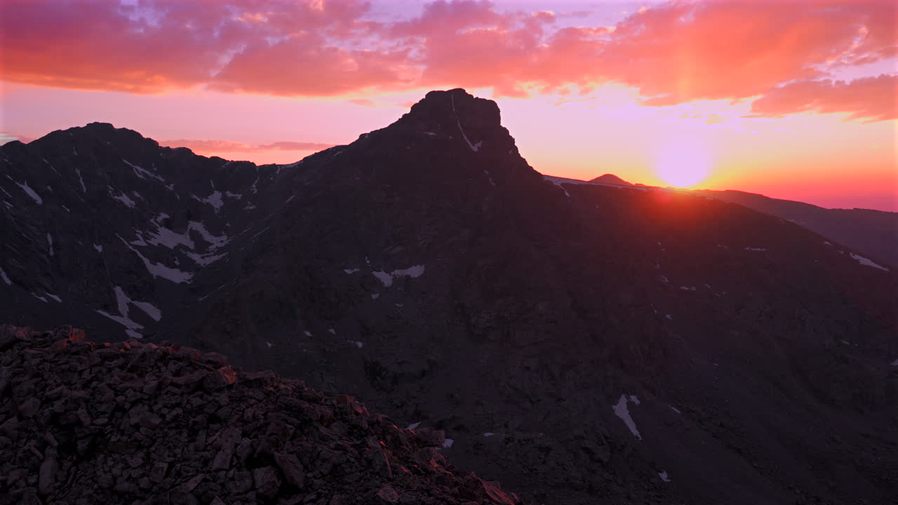 Mount of the Holy Cross Halo Ridge Colorado 14er peak Sawatch Range parallax aerial drone Vail Minturn golden hour vibrant pink sunset on Rocky Mountains horizon Notch Mountain shelter forward motion