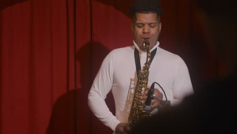 latin man playing sax during live music perfomance