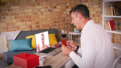 Kaukasisches-Paar-Macht-Einen-Videoanruf-Zum-Valentinstag.-Ein-Mann-Bläst-Einer-Frau-Auf-Dem-Laptop-Bildschirm-Einen-Kuss-Zu