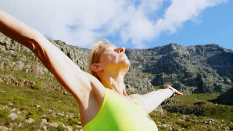 Senior-woman-standing-with-arms-outreached-at-countryside-4k