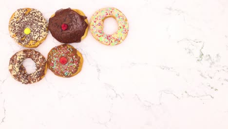 deliciosas rosquillas decoradas para la fiesta aparecen y desaparecen del fondo de mármol - detenga el movimiento