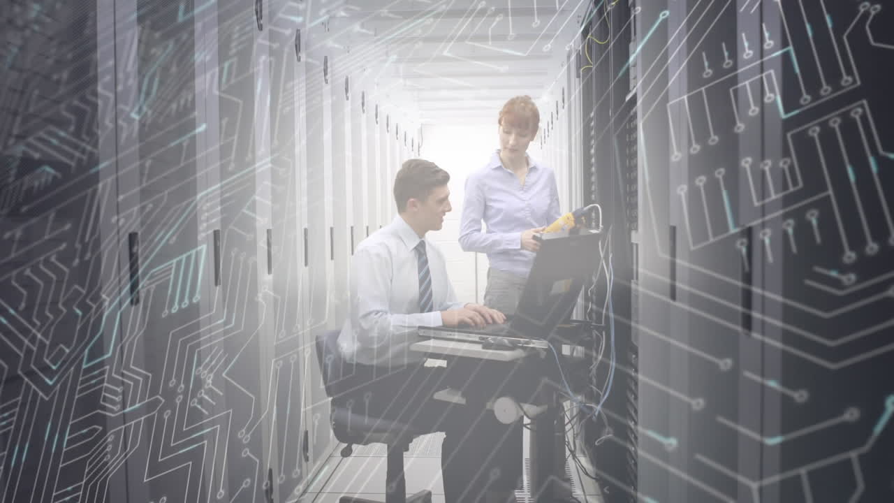 Man and woman working in computer server room while a glowing circuit board moves in foreground