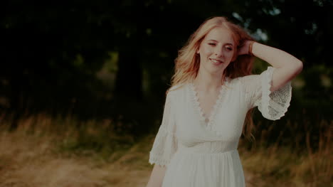 attractive boho woman walking on a meadow in summer holding flowers in hand 2
