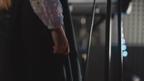 girl adjusts skirt near microphone closeup. young vocalist worried about performing song during recording. little kid shows talent through song