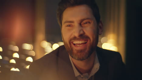 closeup handsome macho laughing evening light apartment. happy man resting date