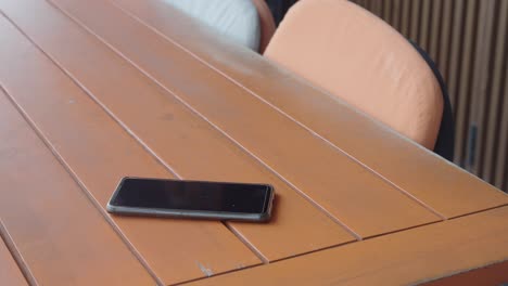 a black phone on a wooden table