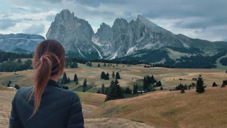 slow motion video of a woman admiring the mountain landscape of alpe di suisi in the dolomites, italy