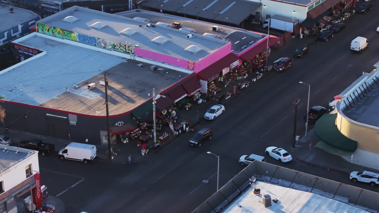 Aerial View of a Bustling City Street with Shops and Traffic
