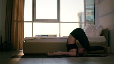 yogi girl doing sarvangasana plow pose from for relaxation heart muscles healing for the spine strengthensrthen back to a lotus pose with namaste. training, yoga at home in the living room