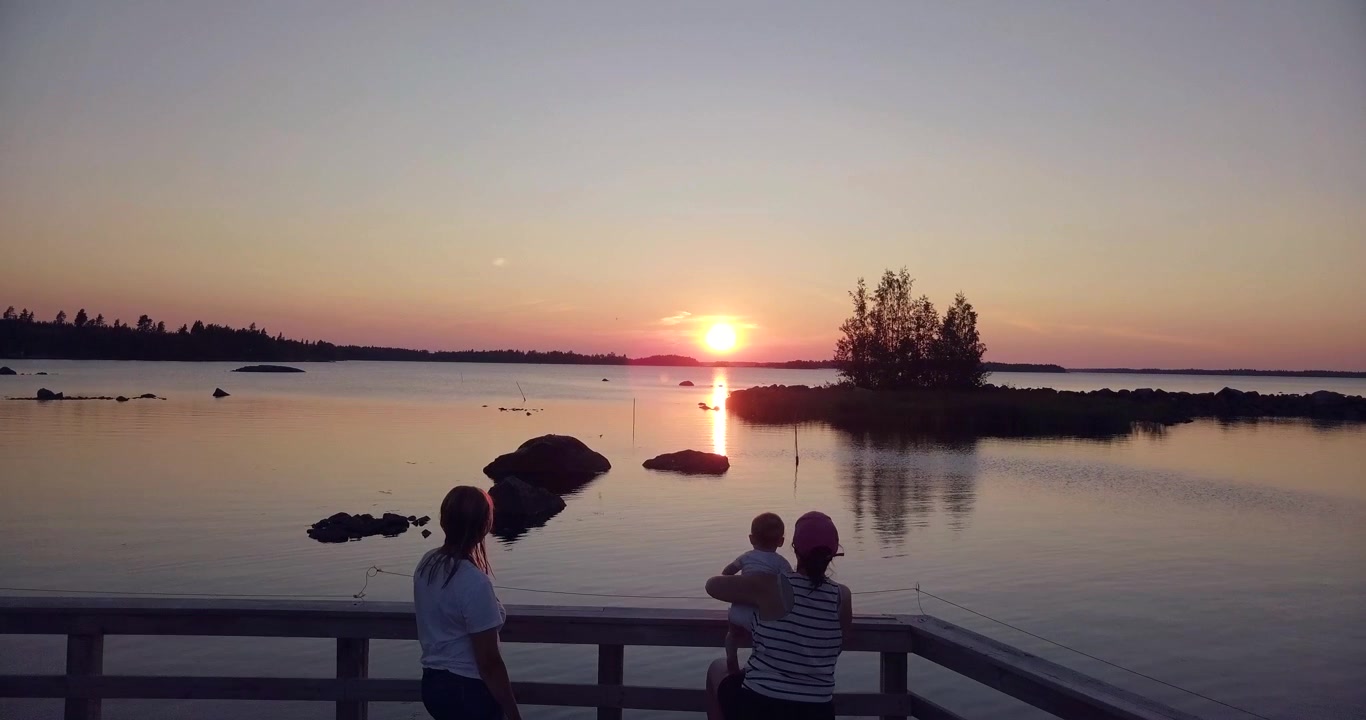 AEREA, Sorelle e bambini che si godono il tramonto dell'ora d'oro al porto.