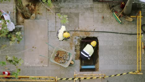 vista superior del trabajador constructor cavando paleando y rompiendo un hormigón en una calle de barcelona