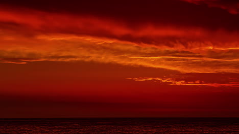 red sunrise with slowly floating clouds over the sea