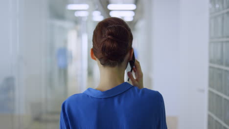 Back-view-girl-talking-mobile-phone-office.-Unknown-woman-meeting-colleague