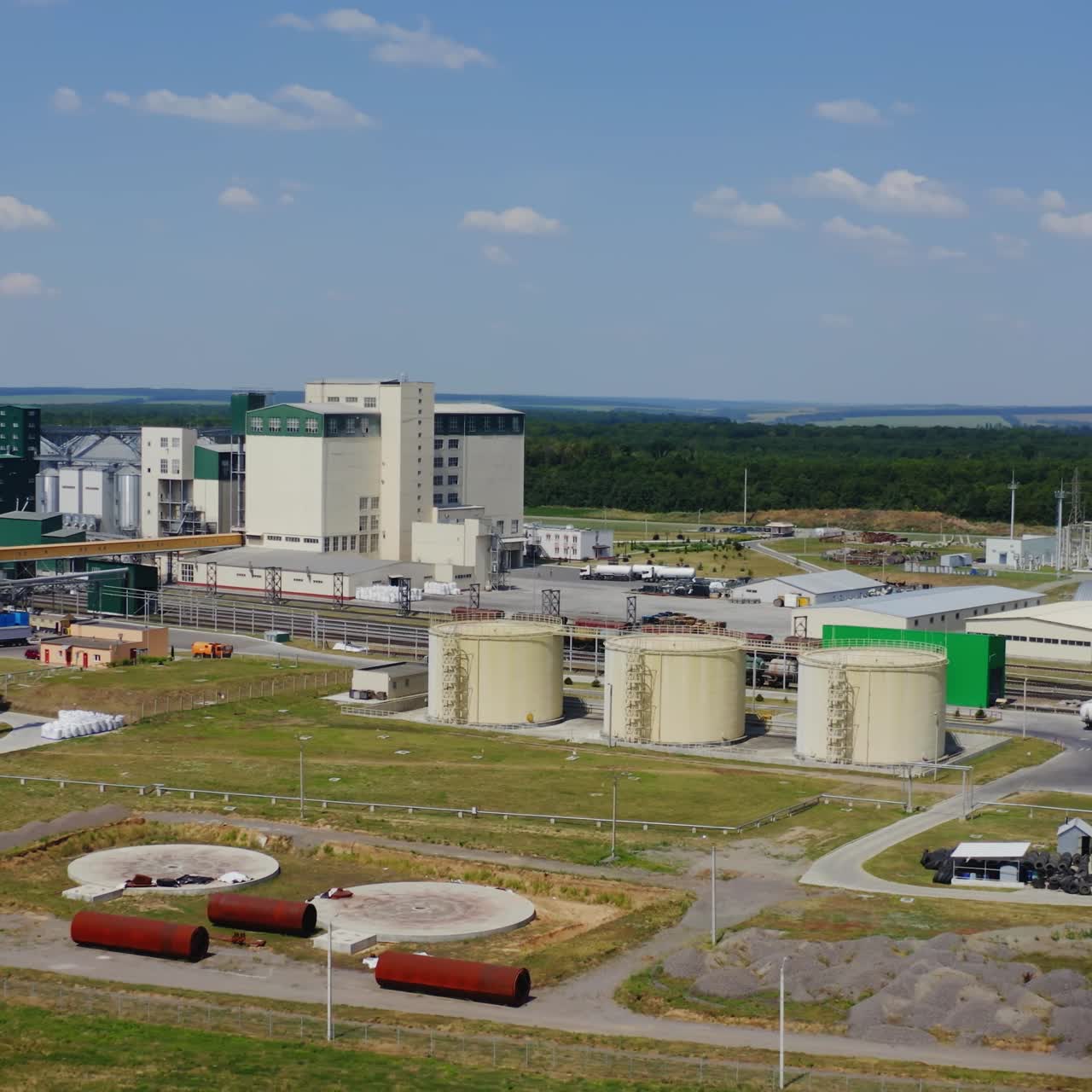 Modern granary elevator. Silver silos on agro-processing and manufacturing plant. Agricultural products, flour, cereals and grain. Aerial view video panorama.