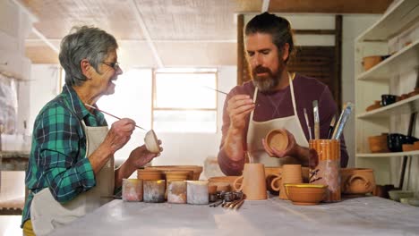 Male-and-female-potter-painting-pots