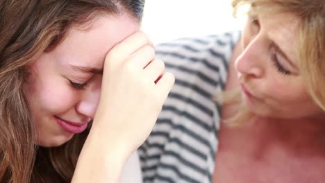 una madre consolando a su hija adolescente