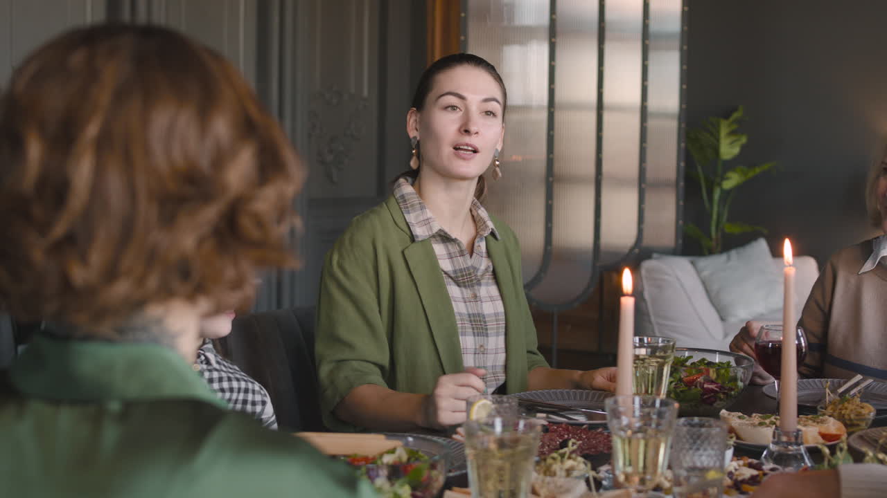 Donna che parla con la sua famiglia mentre cenano insieme a casa