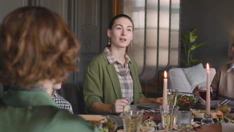 Mujer-Hablando-Con-Su-Familia-Mientras-Cenan-Juntos-En-Casa