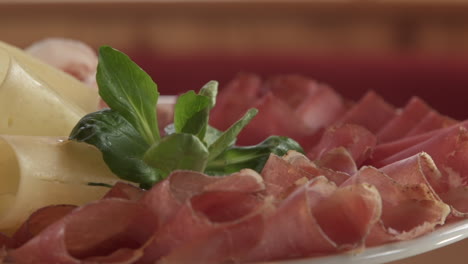 switzerland dish with shaved pieces of air-dried meat, bacon, ham, and cheese on rotating plate