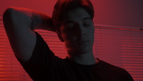portrait of a young man in a neon red light setting