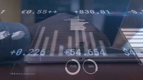 animación de datos financieros y gráficos sobre las manos de un hombre biracial usando una computadora portátil