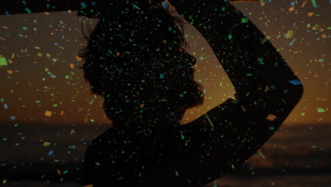 man raising arms at sunset sea view, showcasing marketing strategy with floating confetti particles