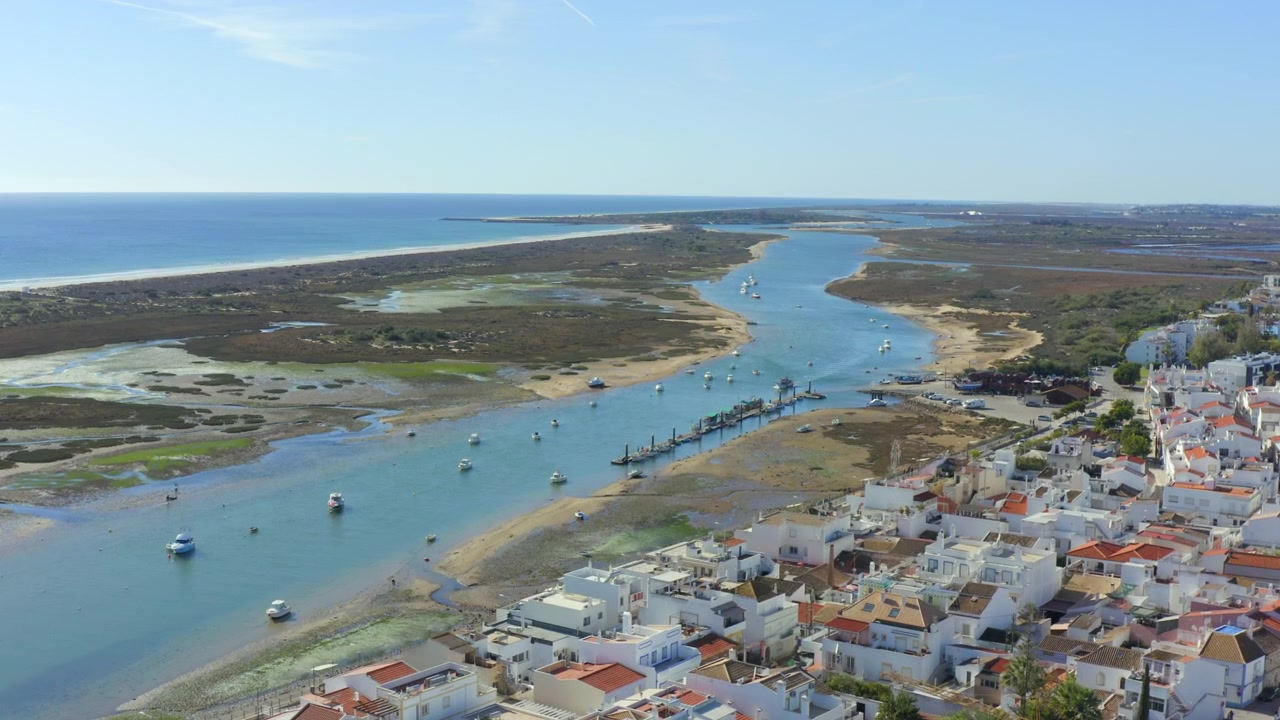 Sorvolo con drone di Cabanas de Tavira verso Ria Formosa con barche ormeggiate, Tavira. Algarve.