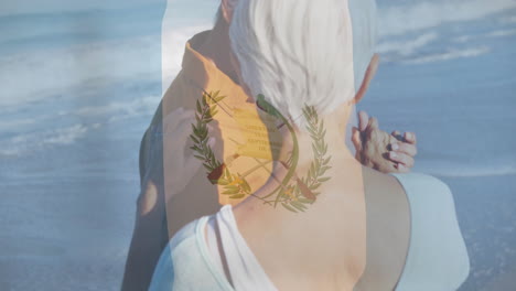 embracing on beach, elderly couple with guatemalan flag animation overlay