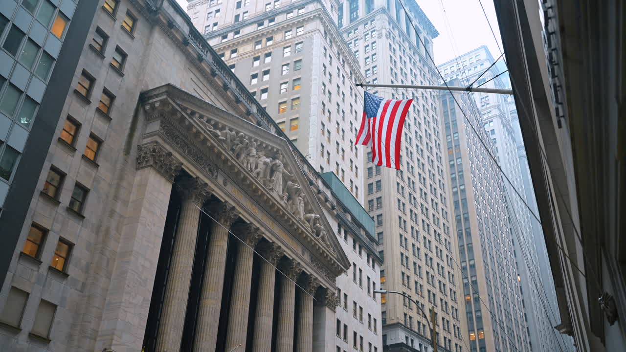 Nova Iorque, EUA, 8 de fevereiro de 2026: Arquitetura neoclássica de uma instituição financeira com a bandeira americana. Vista em ângulo baixo da fachada do edifício da Bolsa de Valores de Nova Iorque