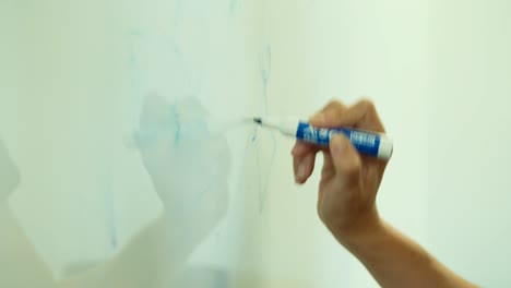 close-up of hands drawing on a whiteboard