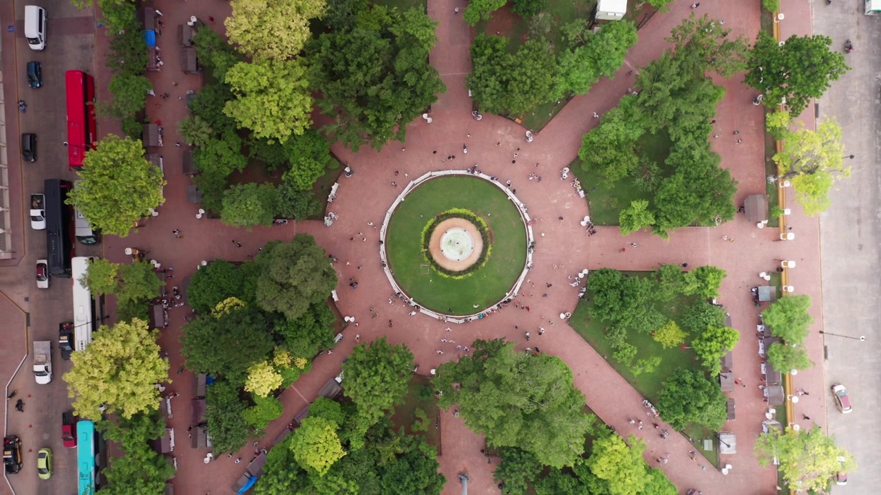 Aerial rising bird's eye shot looking down at Parque Principal Francisco Cantón Rosado in Valladolid, Mexico. 4K
