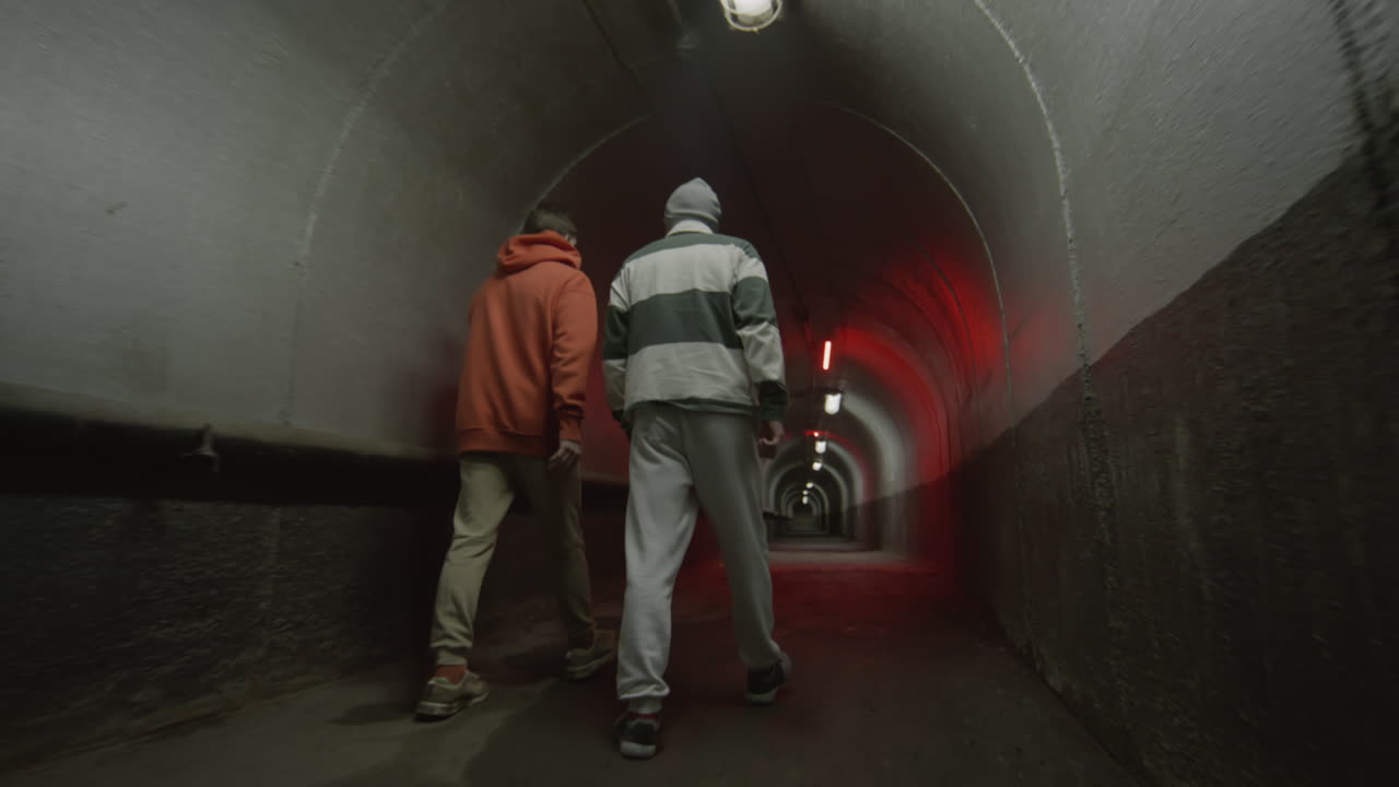 Two Friends Walking in Dark Tunnel and Chatting