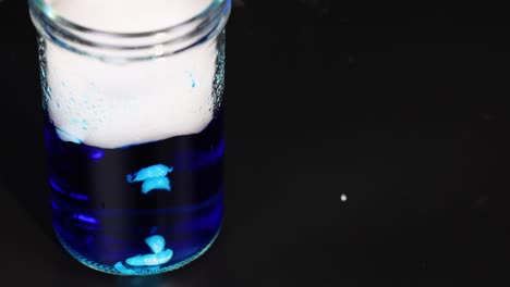 dry ice reacts in blue liquid, creating smoke