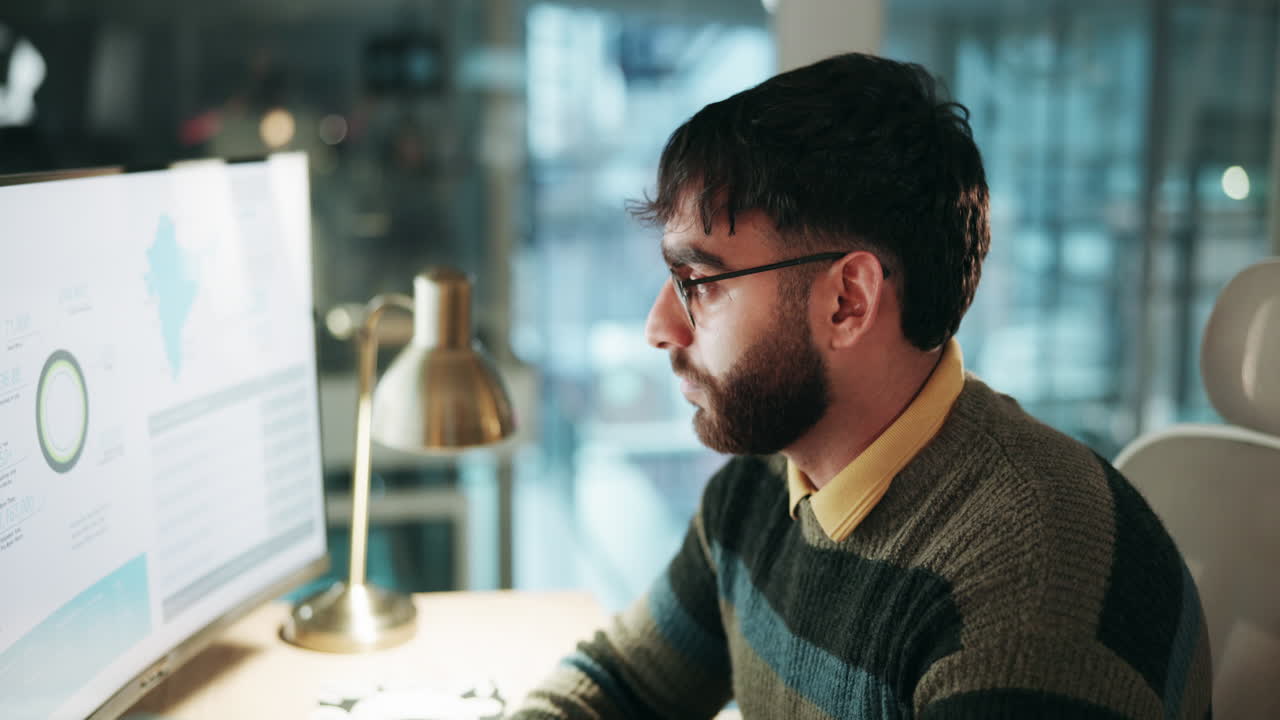 hombre preocupado mirando gráficos de datos en la pantalla de la computadora