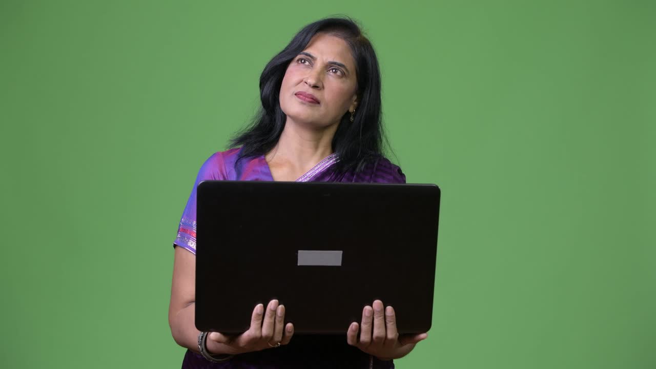 una hermosa mujer india madura pensando mientras el portátil