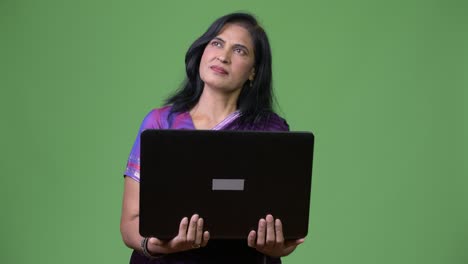 una hermosa mujer india madura pensando mientras el portátil