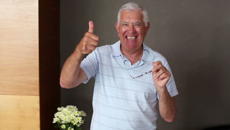 Senior-man-standing-and-smiling-at-camera