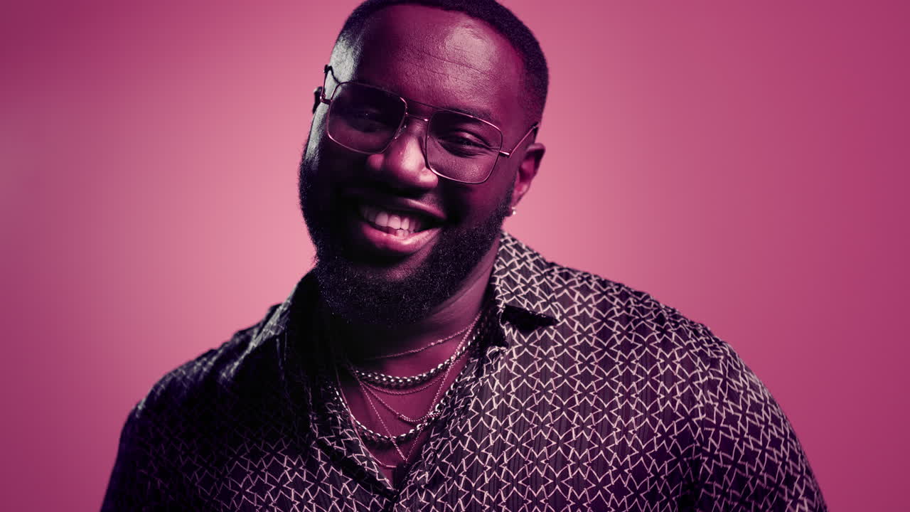 persona masculina feliz sonriendo en el interior. tipo afro mostrando los pulgares en el fondo rosa