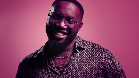 happy male person smiling indoors. afro guy showing thumbs up on pink background