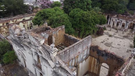 aerial rises over ruin of old art school in santa ana, el salvador